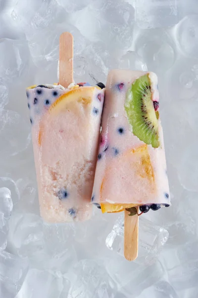 Vue de dessus de délicieuses glaces maison avec des fruits et des baies sur des glaçons — Photo de stock