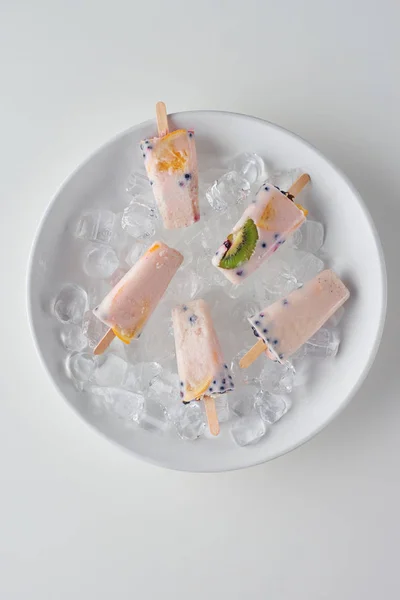 Vista superior de gelado frutado doce frio em cubos de gelo em cinza — Fotografia de Stock