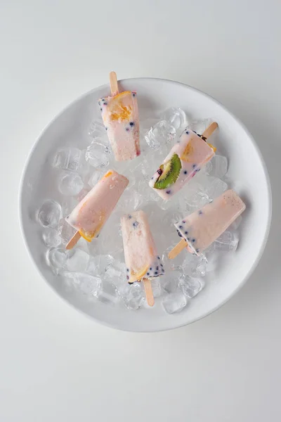 Top view of cold sweet fruity ice cream on ice cubes on grey — Stock Photo