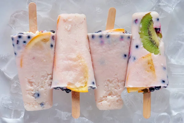 Vista de cerca de deliciosas paletas afrutadas caseras con cubitos de hielo - foto de stock