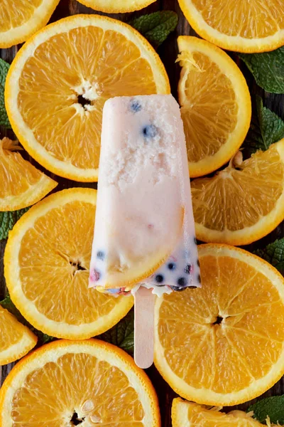 Вид зверху на гастрономічне домашнє морозиво з фруктами та ягодами на апельсинових скибочках — стокове фото