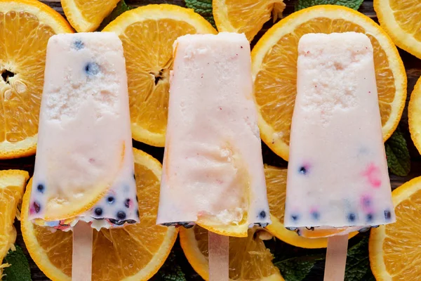 Сверху вид на домашнее мороженое для гурманов с фруктами и ягодами на оранжевых ломтиках — стоковое фото