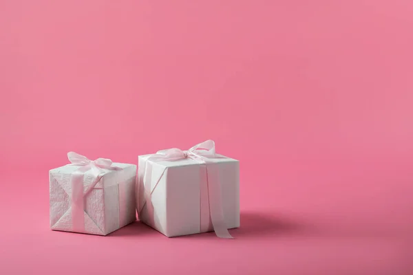 Two gift boxes with bows on pink background — Stock Photo