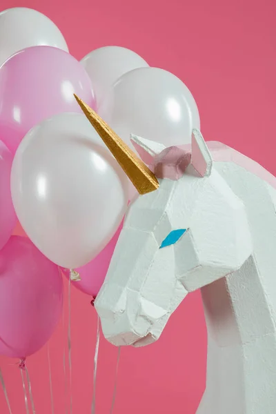 Голова декоративного єдинорога купою кульок ізольовані на рожевому — стокове фото