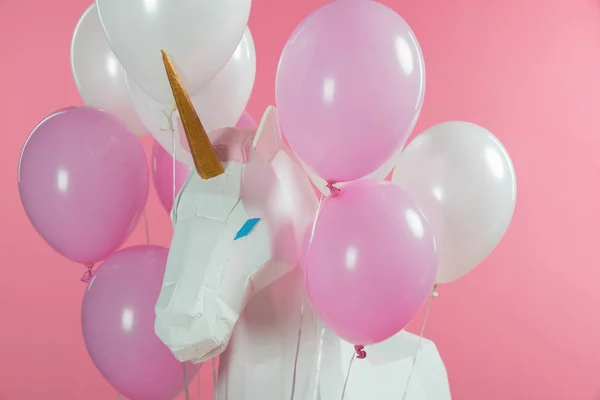 Unicornio mágico con manojo de globos aislados en rosa - foto de stock