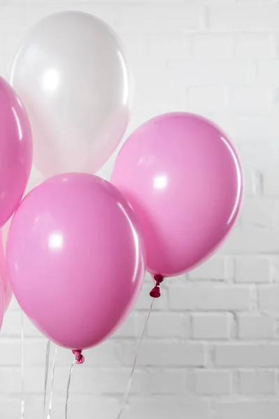 Décoration de fête surprise avec ballons sur fond de mur de brique blanche — Photo de stock