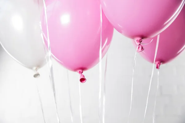 Helle Luftballons auf weißem Backstein-Hintergrund — Stockfoto