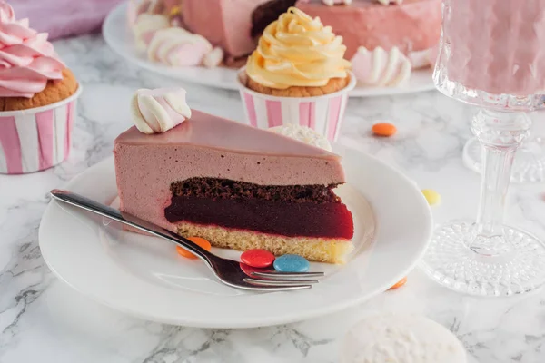 Close up of piece of birthday cake, cupcakes and milkshake on table — Stock Photo