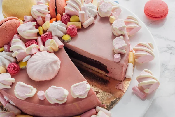 Close up of pink birthday cake with marshmallows, macarons and candies — Stock Photo