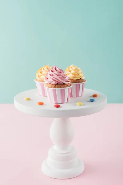 Cupcakes with buttercream and candies on cake stand — Stock Photo