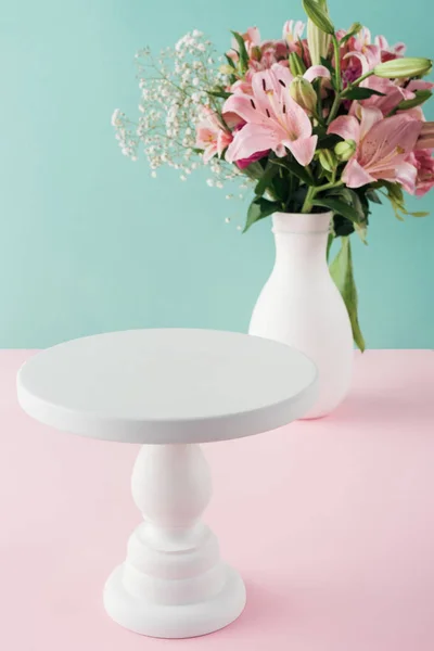 Empty white cake stand and bouquet of flowers in vase — Stock Photo