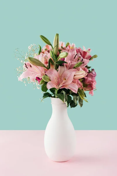 Vaso branco com flores de lírio rosa no fundo pastel — Fotografia de Stock