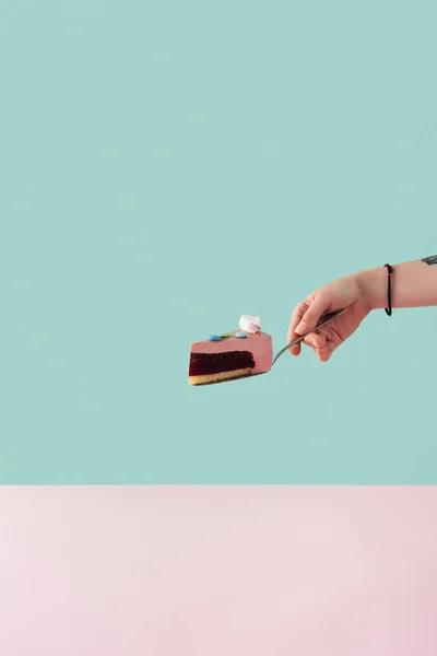 Cropped view of tattooed hand with piece of cake with marshmallow on cake shovel — Stock Photo