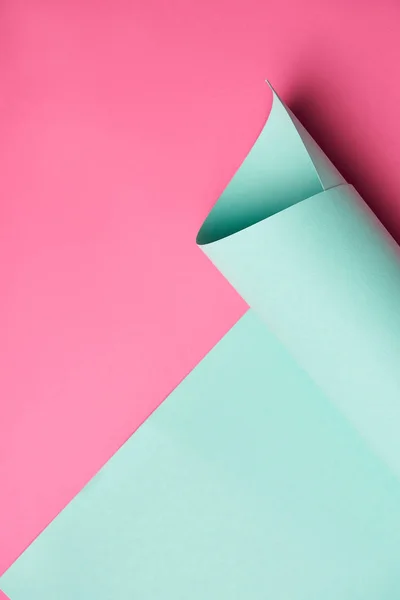 Close-up view of rolled turquoise paper on creative pink background — Stock Photo