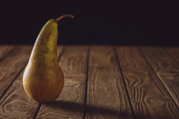 Gros plan de poire mûre sur table rustique en bois noir — Photo de stock