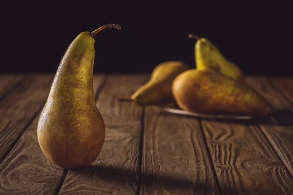 Primer plano de uvas amarillas maduras sobre mesa rústica de madera sobre negro - foto de stock