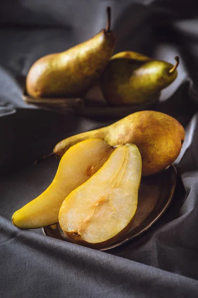 Close-up shot of sliced ripe pears on grey drapery — Stock Photo