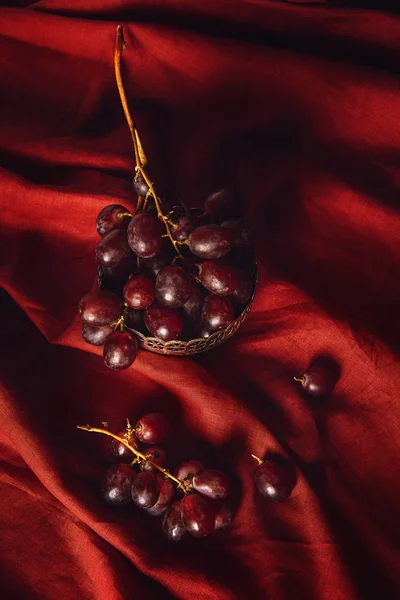 Close-up shot of grapes in vintage metal bowl on red drapery — Stock Photo