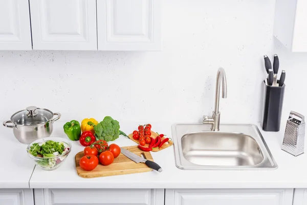 High angle view of tomatoes and chili peppers on cutting boards in light kitchen — Stock Photo