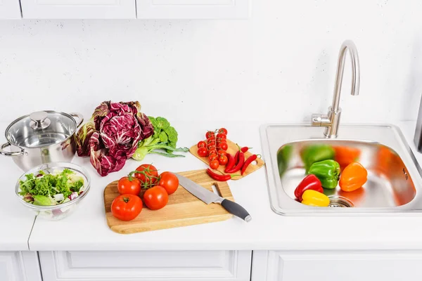 High angle view of ripe vegetables on cutting boards in light kitchen — Stock Photo