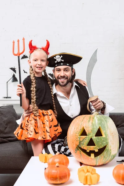 Glückliche Tochter und Vater in Halloween-Kostümen zu Hause — Stockfoto