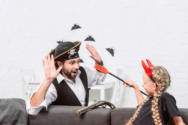 Porträt von Tochter und Vater in Halloween-Kostümen beim Spielen zu Hause — Stockfoto