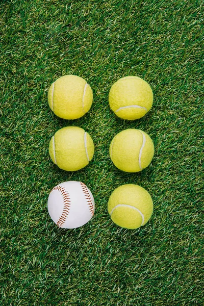 Tendido plano con arreglo de pelotas de tenis y béisbol sobre hierba verde - foto de stock