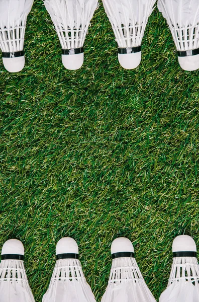 Top view of white shuttlecocks arranged on green grass — Stock Photo
