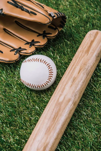 Close up view of baseball equipment arranged on green grass — Stock Photo