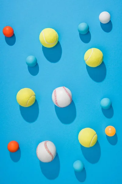 Vue de dessus de pin pong arrangé, balles de tennis et de baseball sur fond bleu — Photo de stock