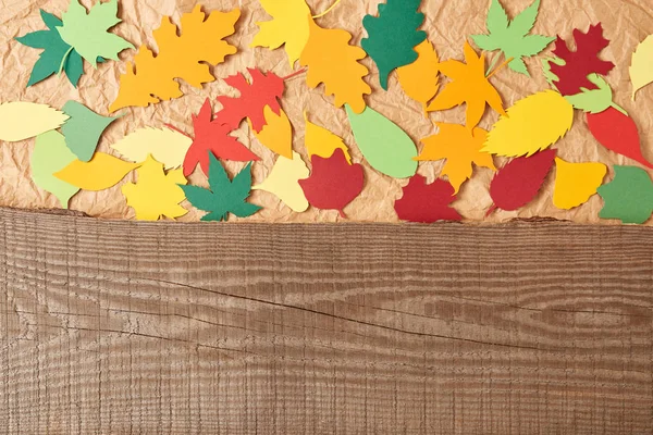 Vista superior de tablón de madera y hojas de papel colorido disposición sobre fondo de papel arrugado — Stock Photo