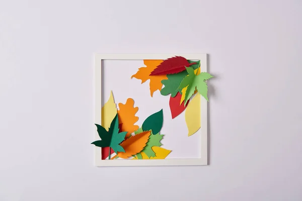 Flat lay with handcrafted paper leaves and frame on white tabletop — Stock Photo