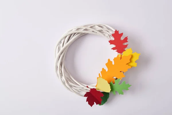Top view of handmade wreath with colorful paper foliage on white backdrop — Stock Photo
