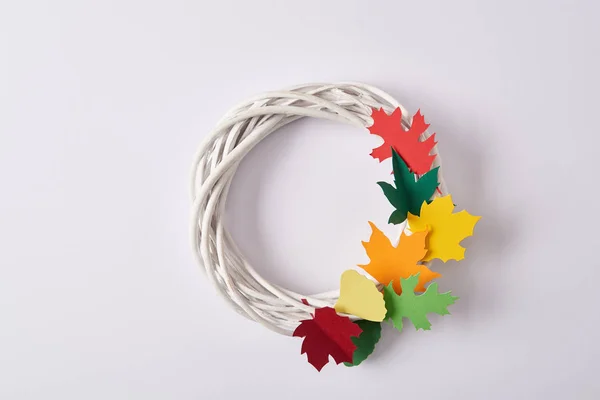 Top view of handmade wreath with colorful paper foliage on white backdrop — Stock Photo