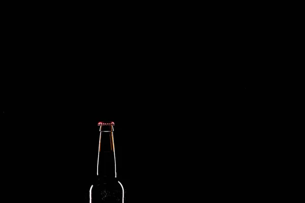 Bouteille de bière sombre isolée sur fond noir, concept minimaliste — Photo de stock