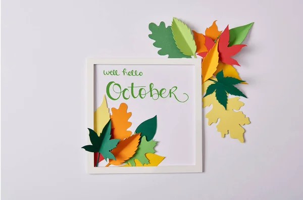 Flat lay with handcrafted paper leaves and white frame with 