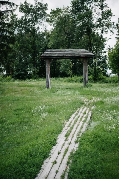 Sentier en planches de bois et portail en bois dans un parc verdoyant — Photo de stock