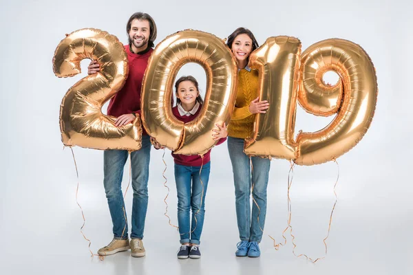 Glückliche Eltern mit Tochter halten Schild 2019 aus goldenen Luftballons für das neue Jahr isoliert auf weißem Hintergrund — Stockfoto