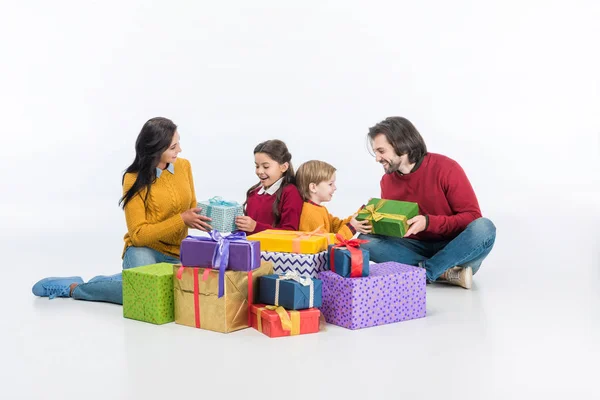Щасливі батьки і діти з загорнутими подарунковими коробками ізольовані на білому — стокове фото