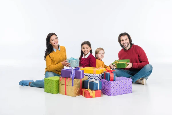 Усміхнена сім'я з загорнутими подарунковими коробками ізольовані на білому — стокове фото