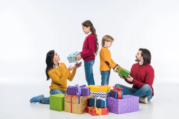 Усміхнена сім'я з загорнутими подарунками ізольовано на білому — стокове фото