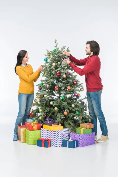 Couple decorating christmas tree with glass balls isolated on white — Stock Photo