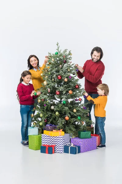 Happy family decorating christmas tree with presents isolated on white — Stock Photo