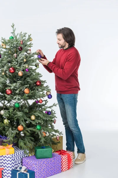 Feliz padre decorando árbol de Navidad con bolas de vidrio aisladas en blanco - foto de stock