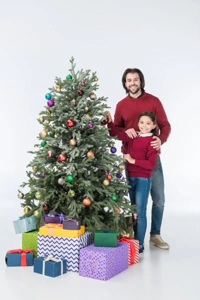 Feliz padre con hija decorando árbol de Navidad con regalos aislados en blanco - foto de stock