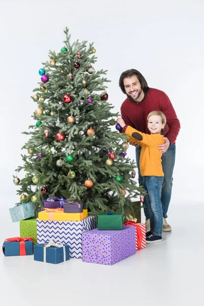 Père heureux avec fils décorant arbre de Noël avec des cadeaux isolés sur blanc — Photo de stock