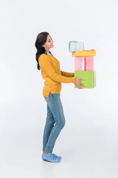 Lächelnde Frau mit eingewickelten Geschenken auf weißem Grund — Stockfoto