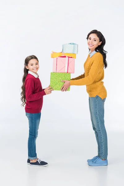 Lächelnde Mutter und Tochter mit verpackten Geschenken auf weißem Grund — Stockfoto