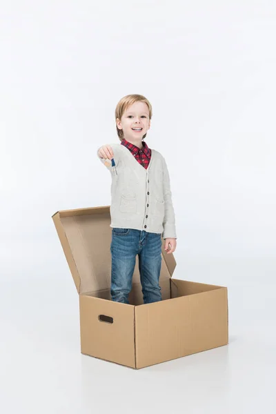 Happy little boy holding key from new house ready to move into new house isolated on white — Stock Photo