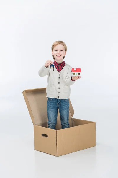 Little boy holding carton house and key from new house ready to move into new house isolated on white — Stock Photo